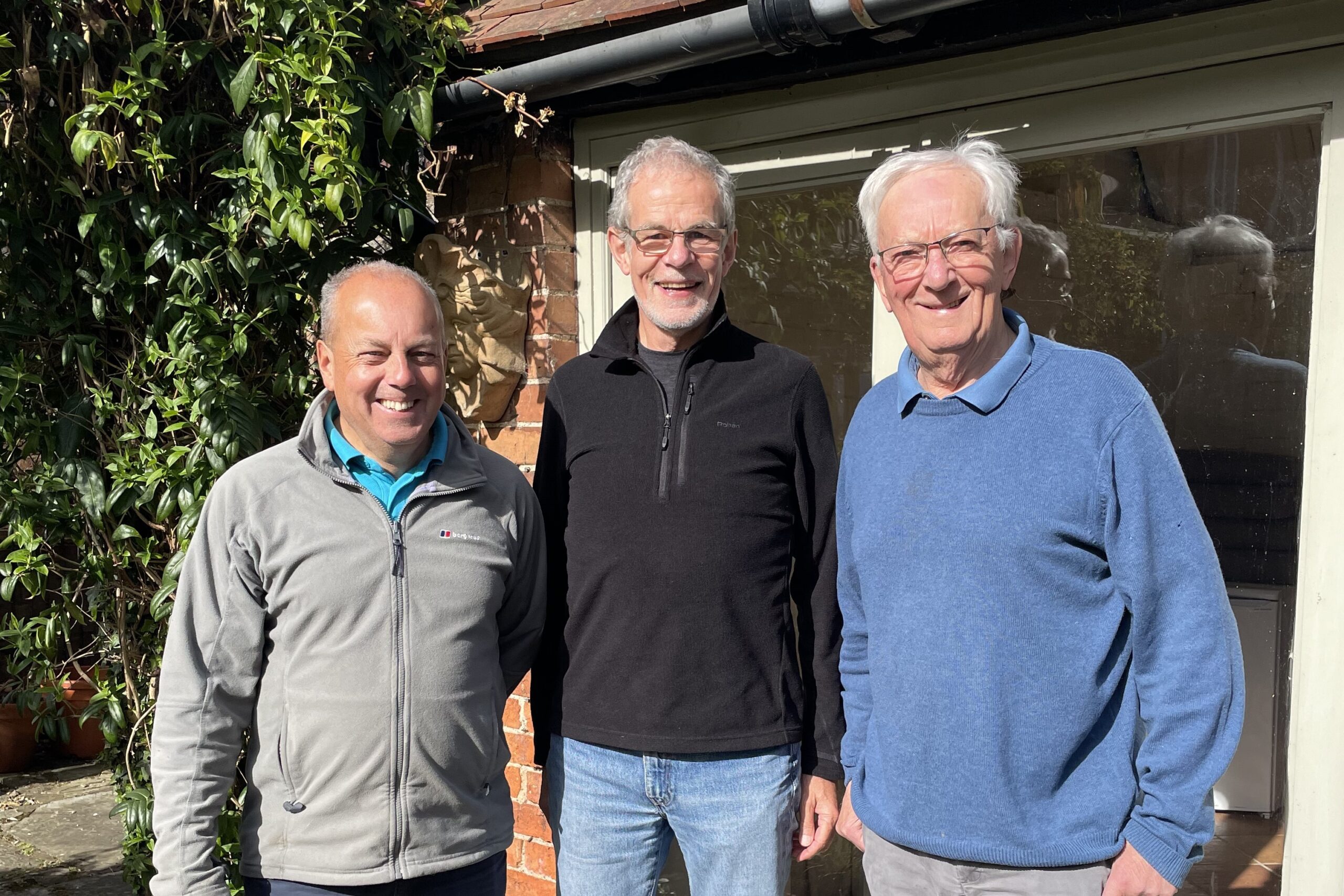 Three founding members of Crowle Community Energy stood in a garden.