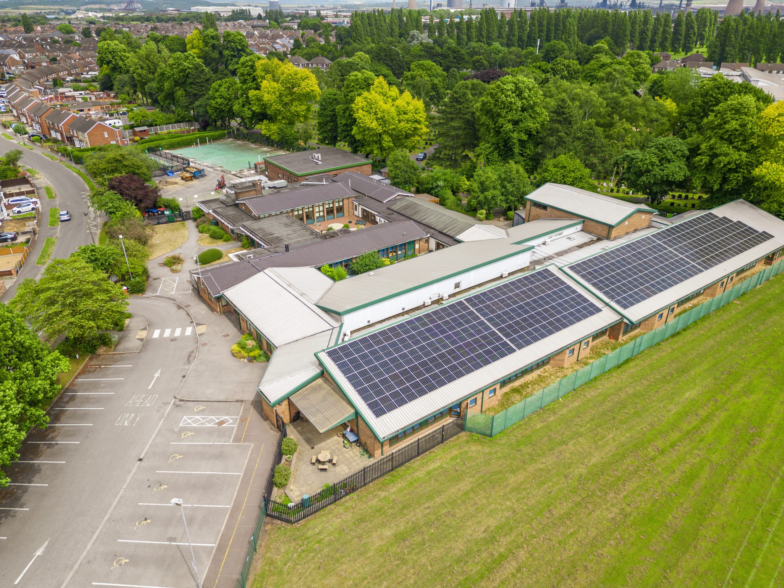 Two primary school buildings with solar panels on their roofs.