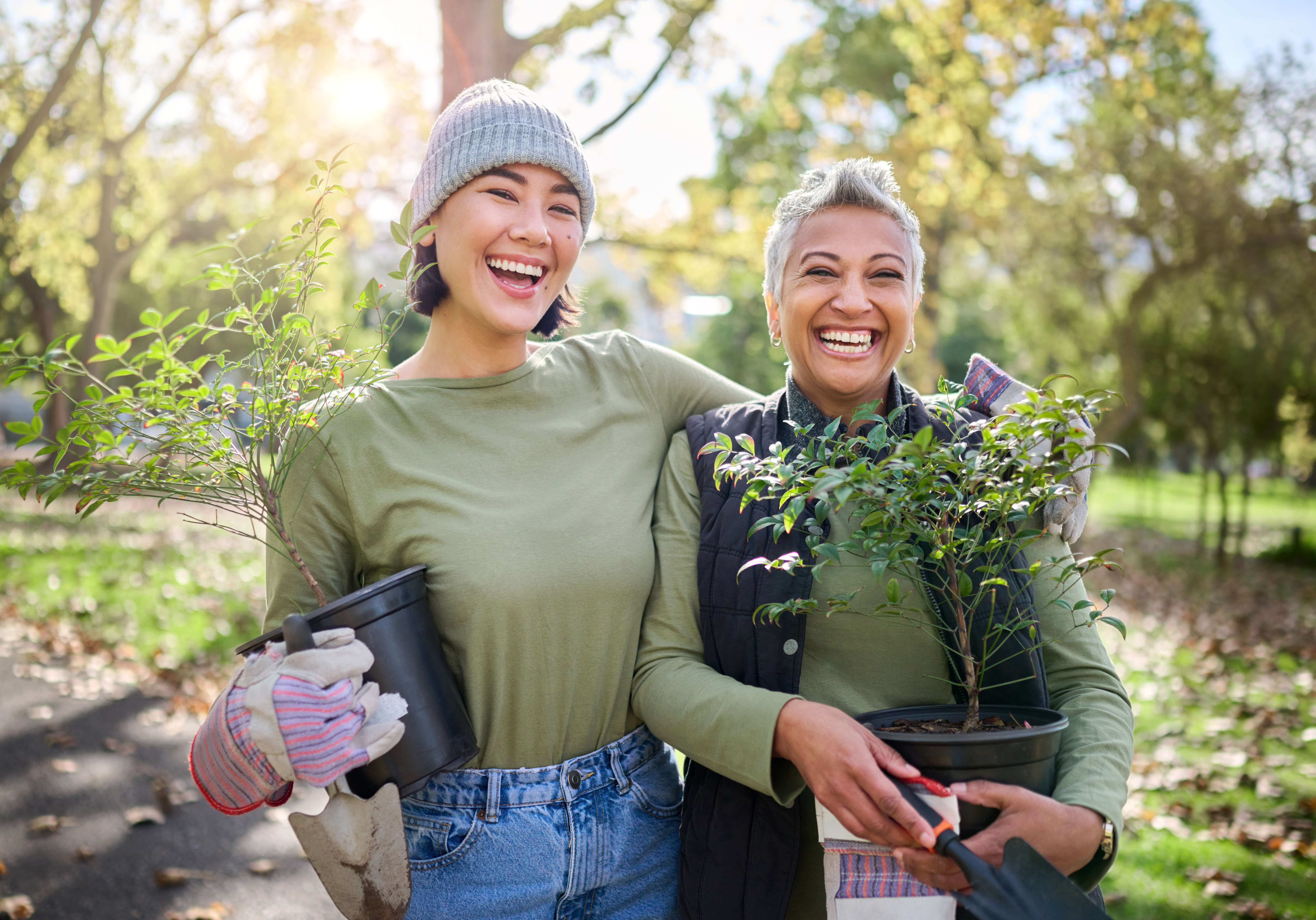 Volunteers stood holding plants ready to work in a community garden.