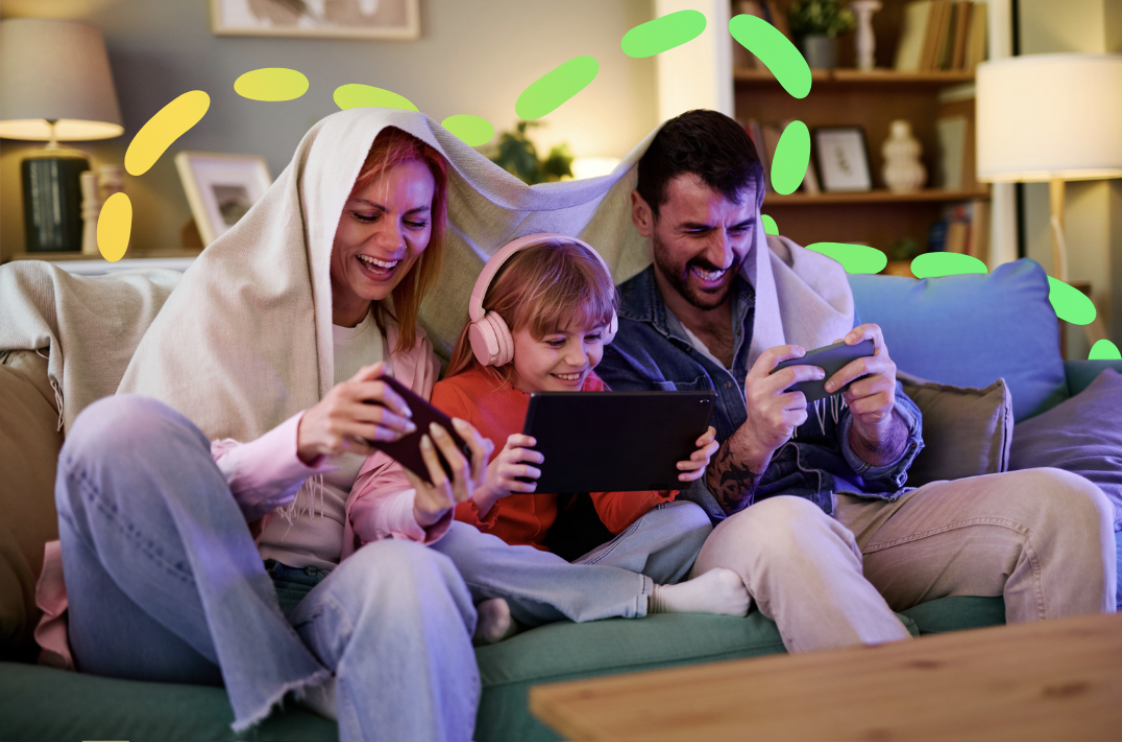 A family using electronic devices at home on the sofa.