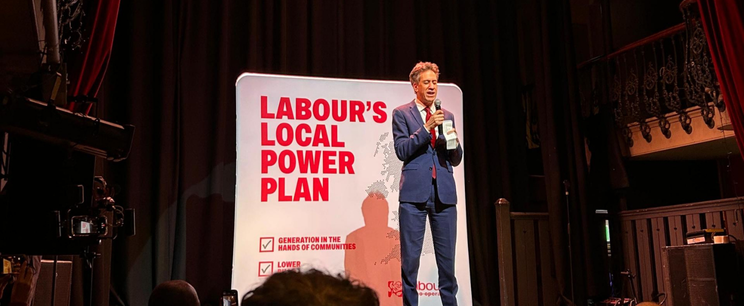 an MP speaking on stage speaking to an audience at a conference.