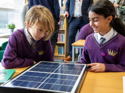 Children actively engaging with solar technology during a hands-on Solar for Schools workshop, exploring how clean energy works.