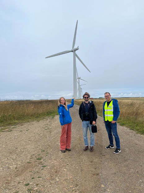 The Younity team stood at the base of one of the Westmill turbines during a tour.