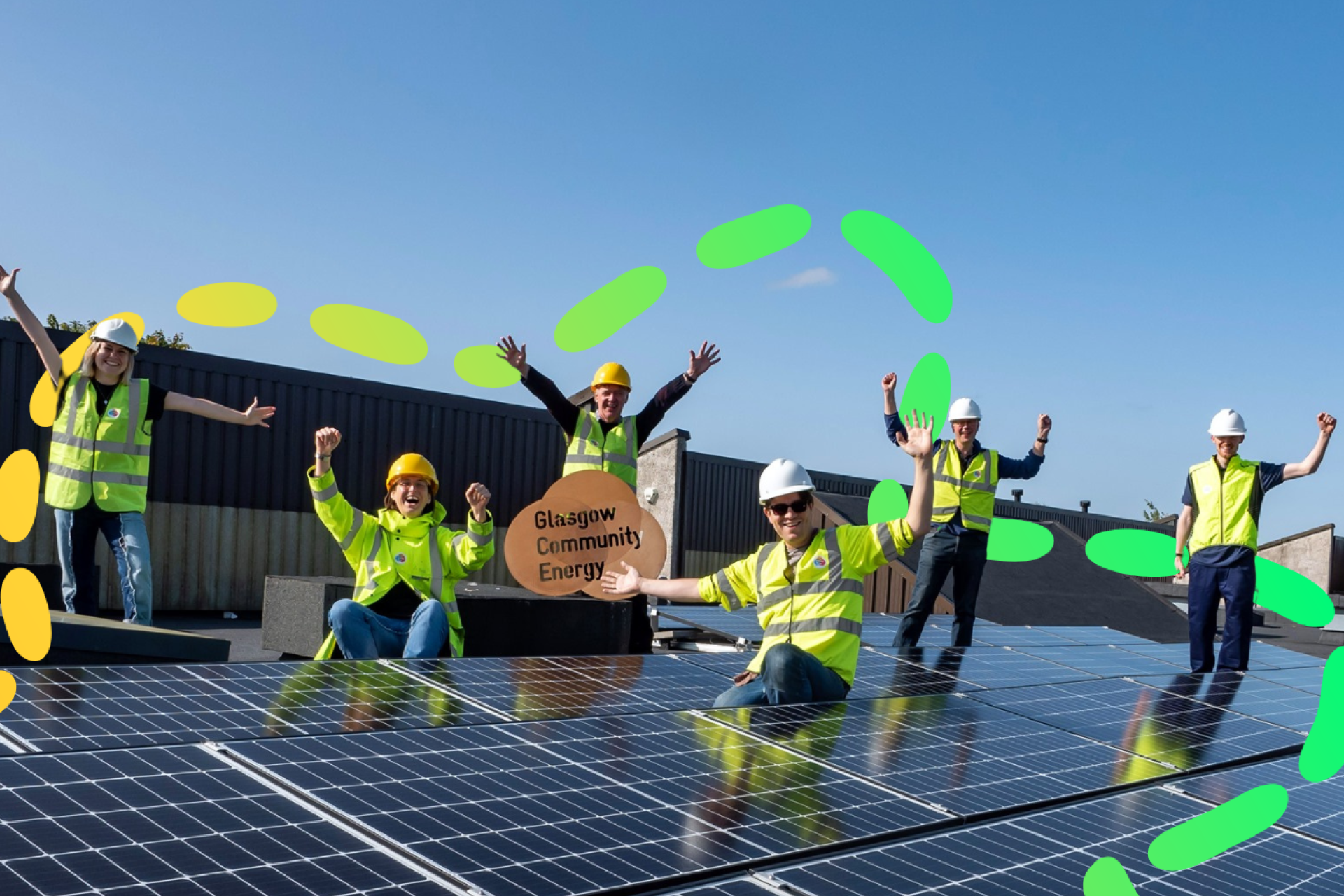 Members of Glasgow Community Energy celebrating by their solar installation. 