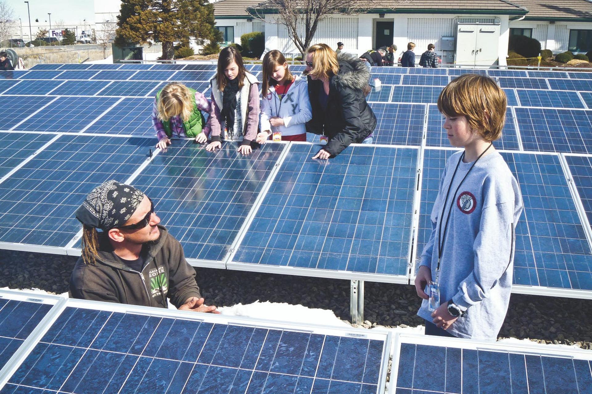 Volunteers showing children how solar panels work