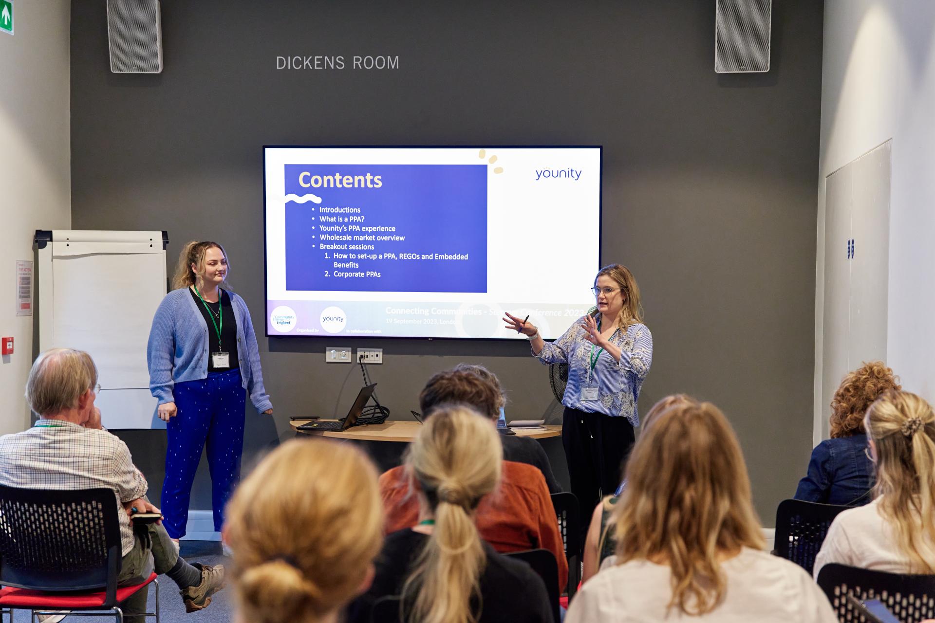 Younity team members presenting on Power Purchase Agreements at a community event, discussing renewable energy solutions.