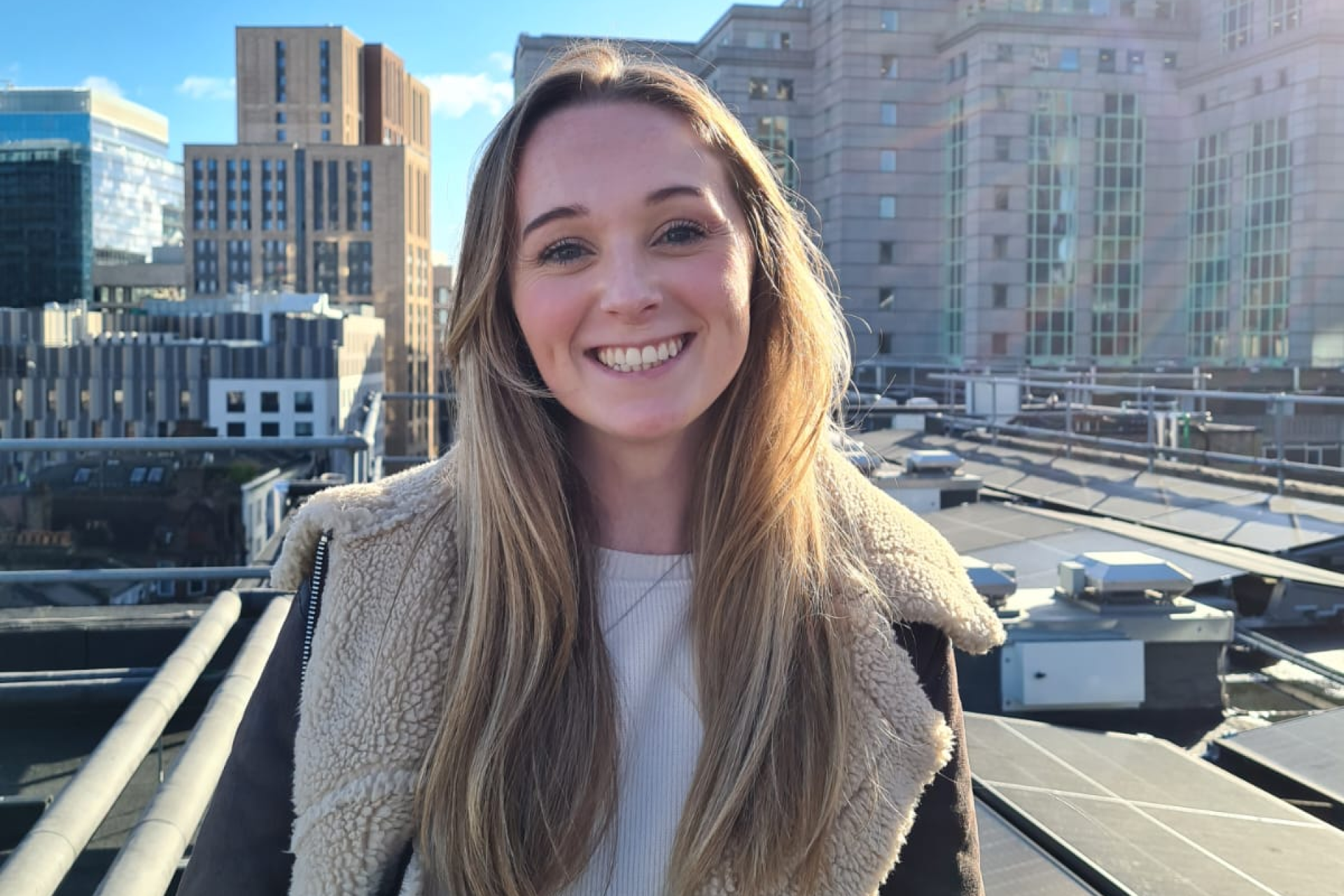 Jessica Dunning on a rooftop with solar panels, supporting community energy