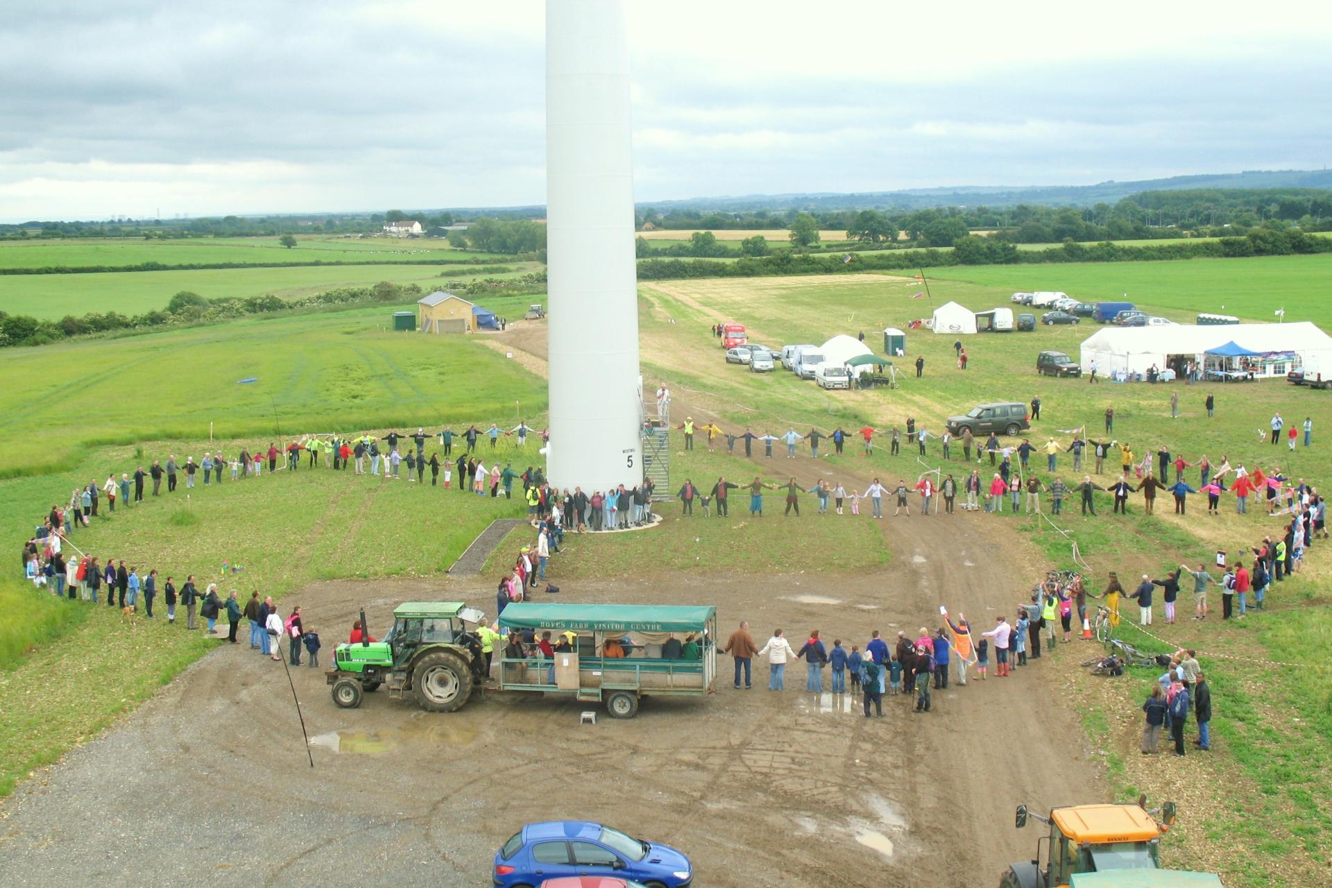 Westmill Wind Co-operative members standing in front of their wind turbine.