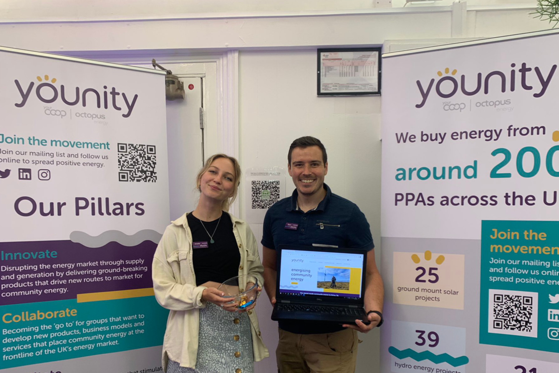 Younity colleagues at an event in front of branded banners.