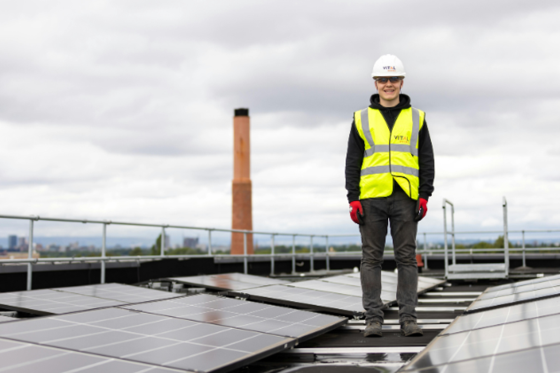 Engineer inspecting rooftop solar panels on a high-rise building, symbolising the future of clean energy.