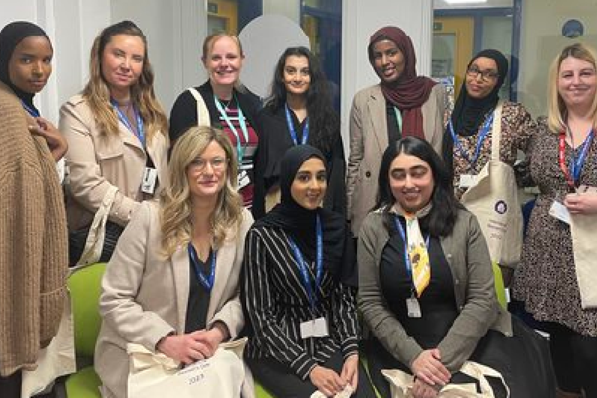 Michaela posing with school students after speaking at an event.