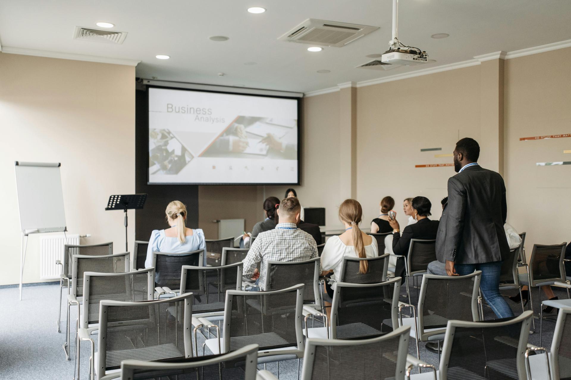 People taking their seats at a conference before it begins.