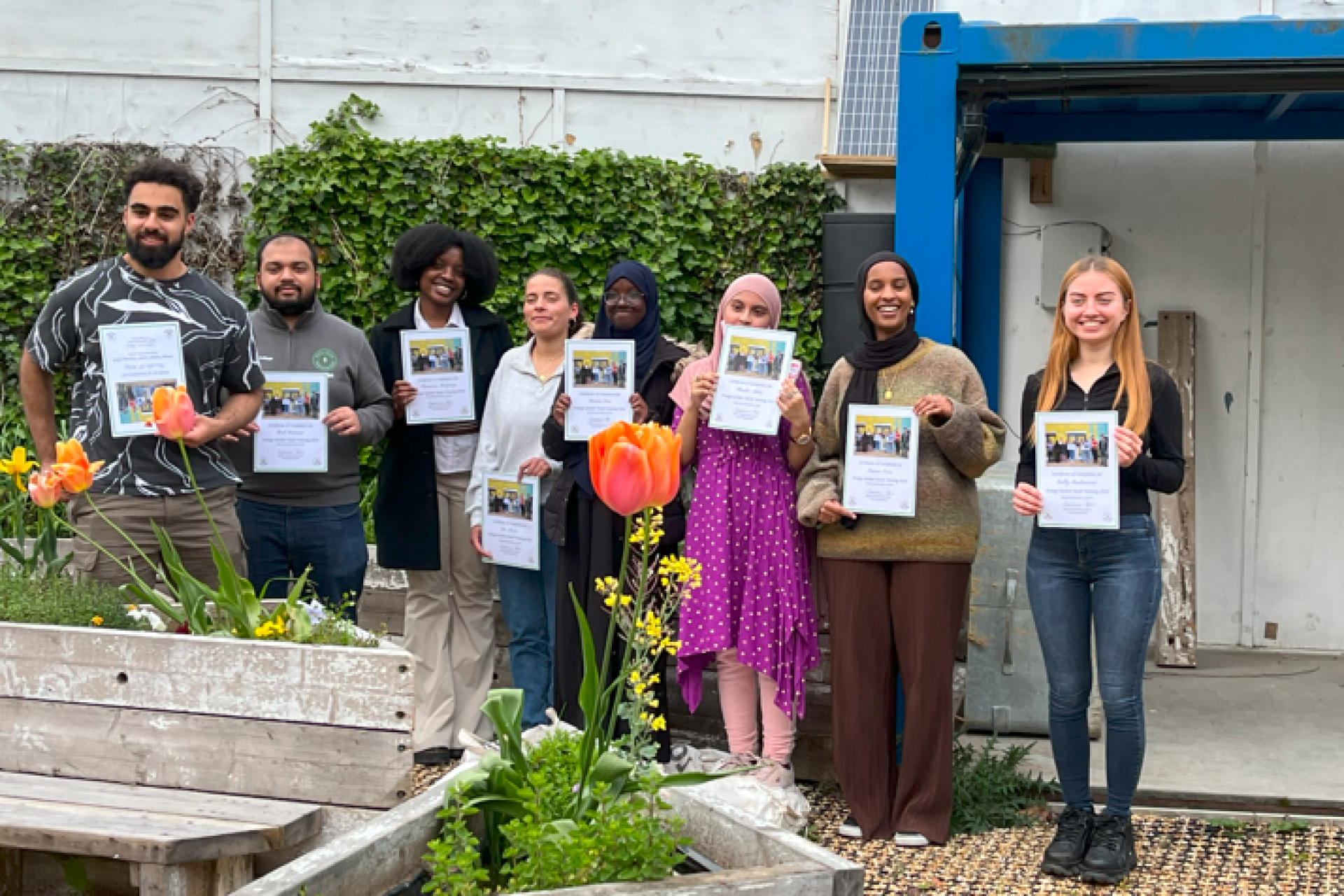 Graduates of the Youth Training Programme proudly holding their awards.