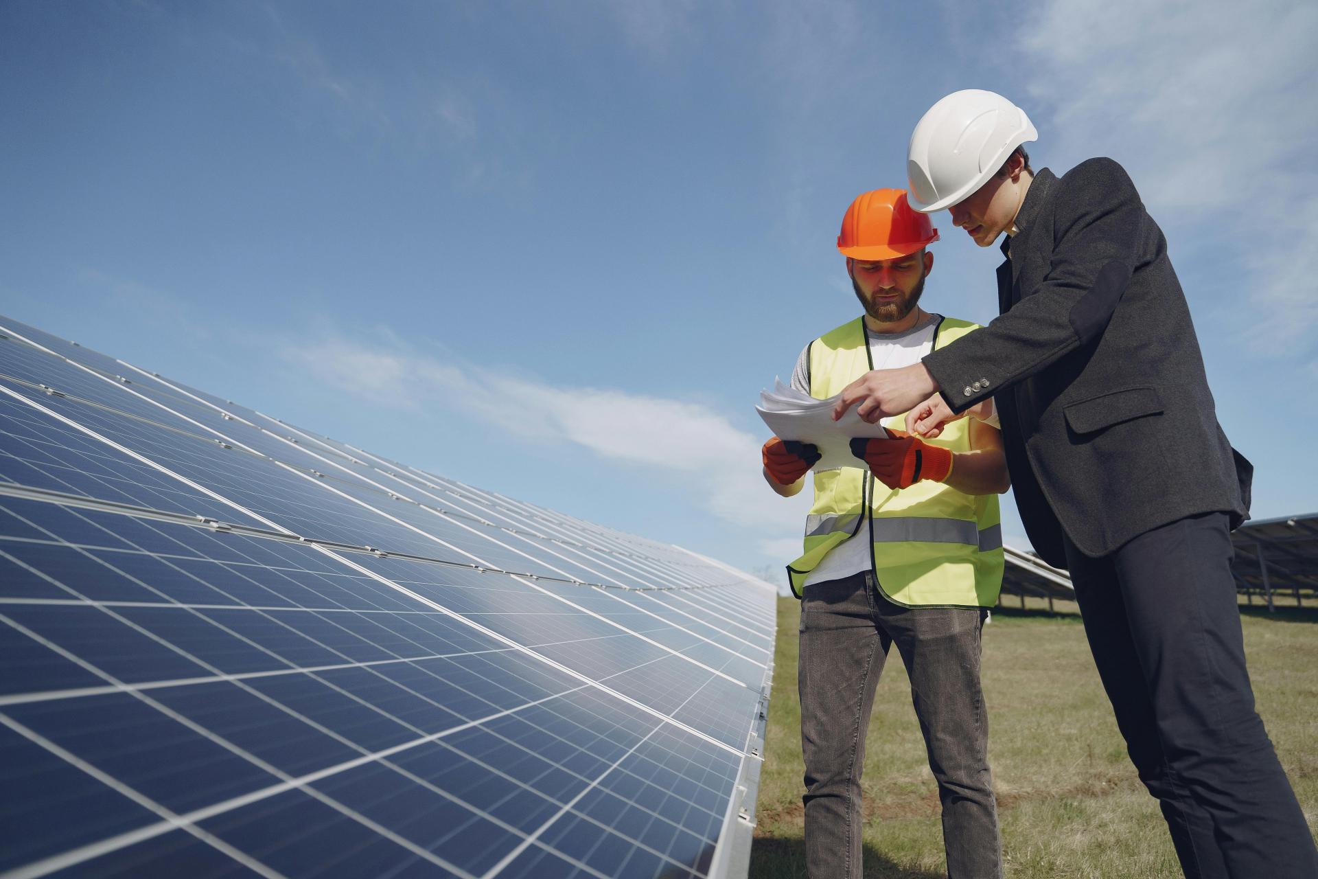 Engineers inspecting solar panels at a renewable energy project.