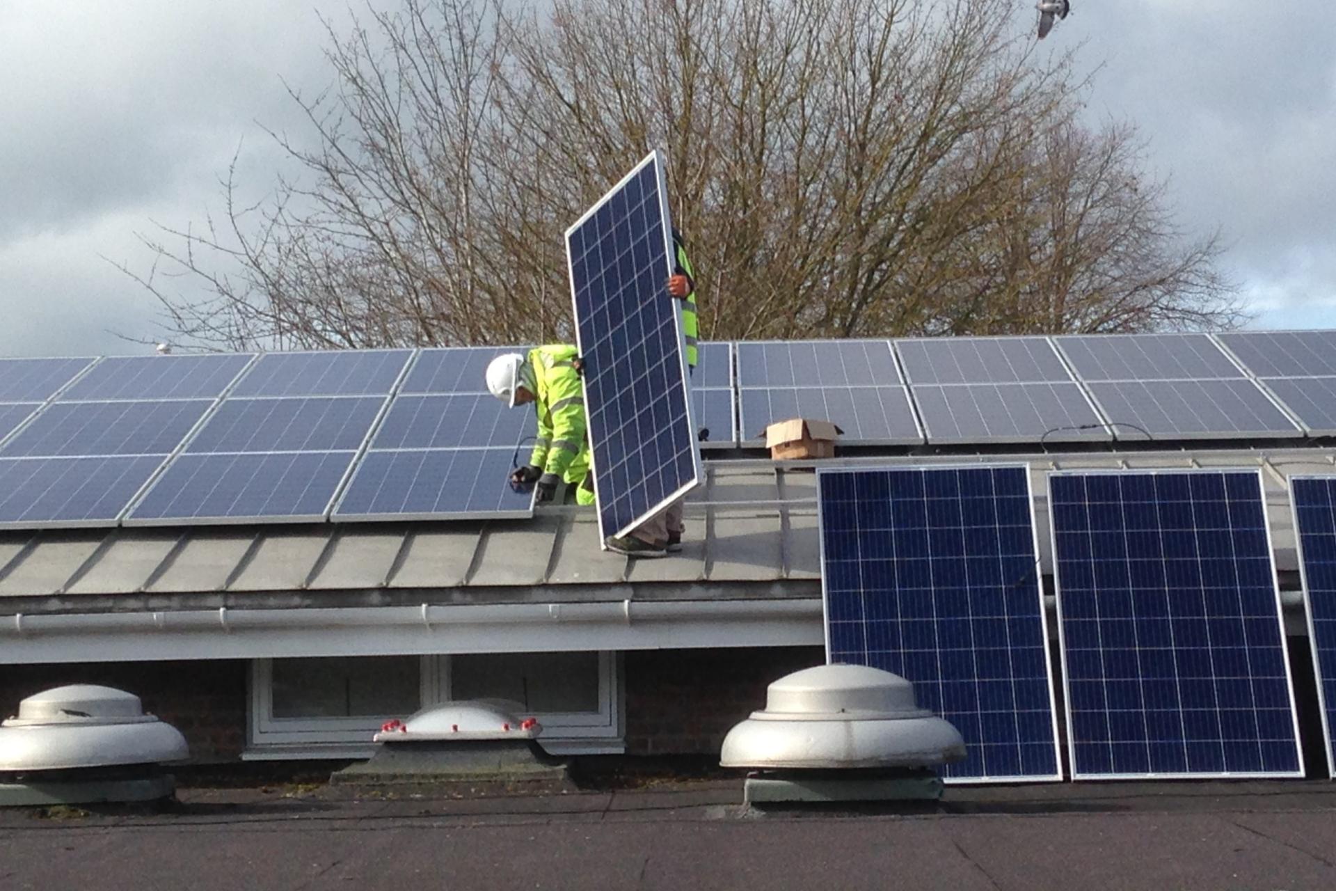 Engineer installing solar panels for clean energy.