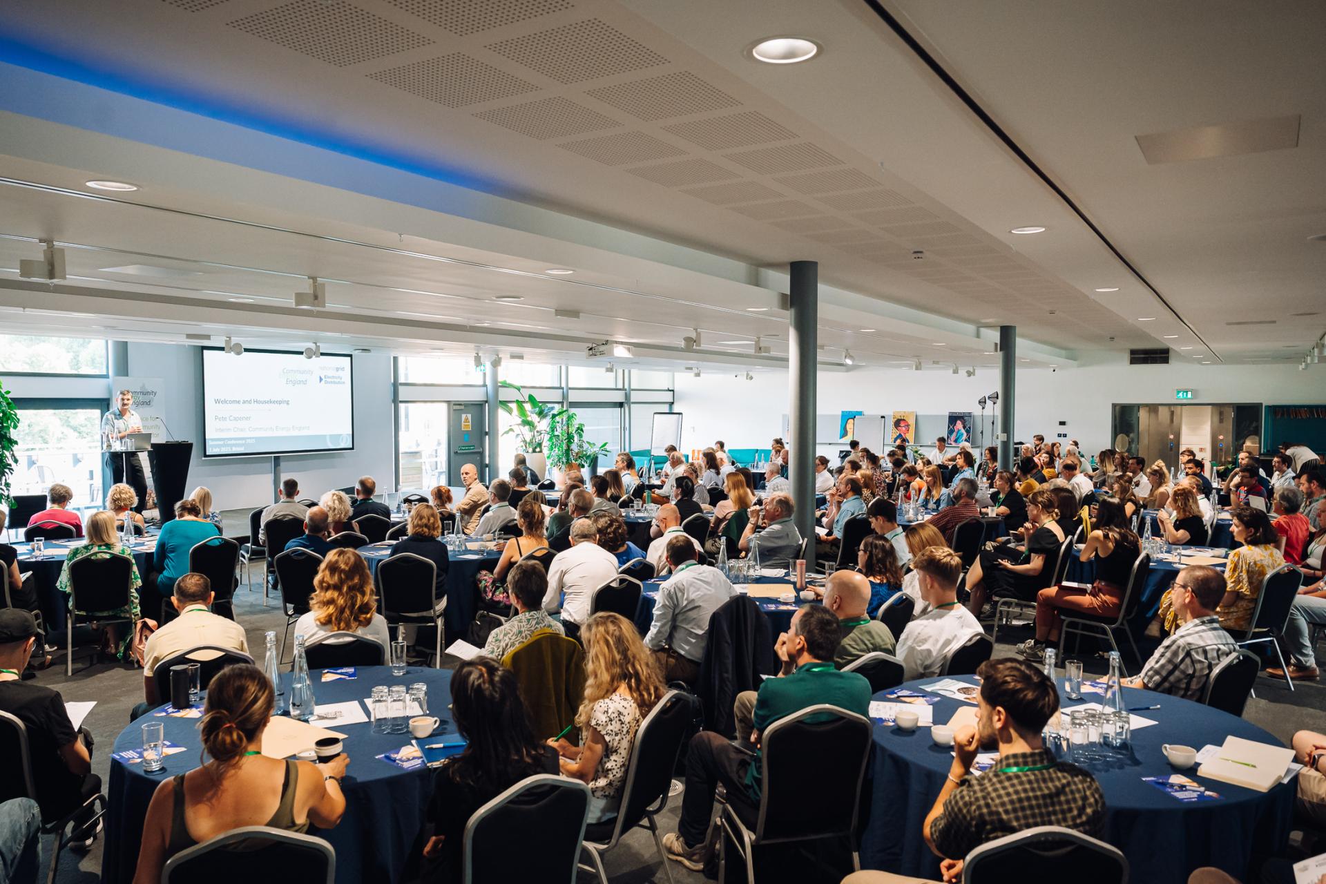A picture taken at a previous Community Energy England conference, showing a full room during a presentation.