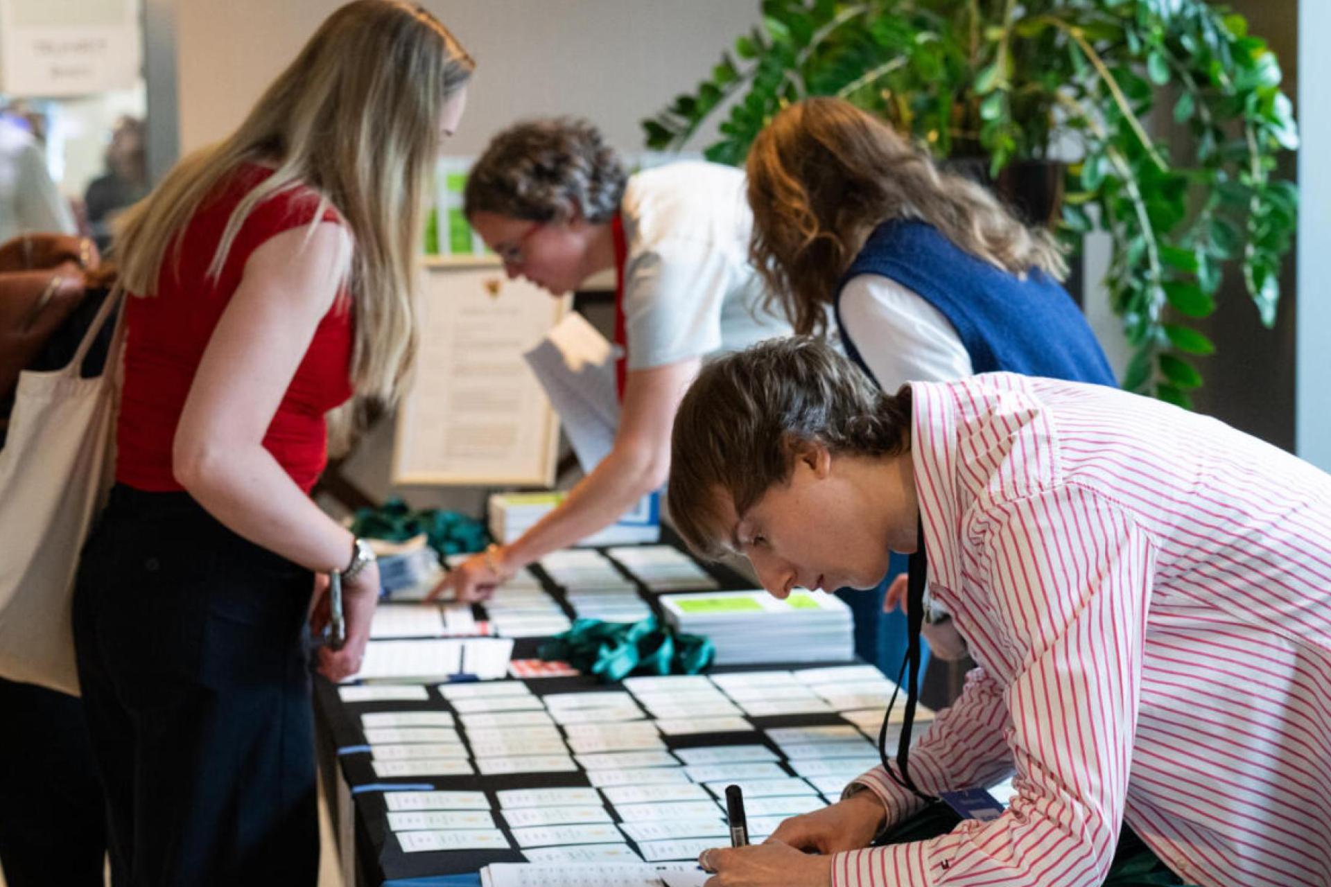 An event attendee collecting their name badge from a table during an event.