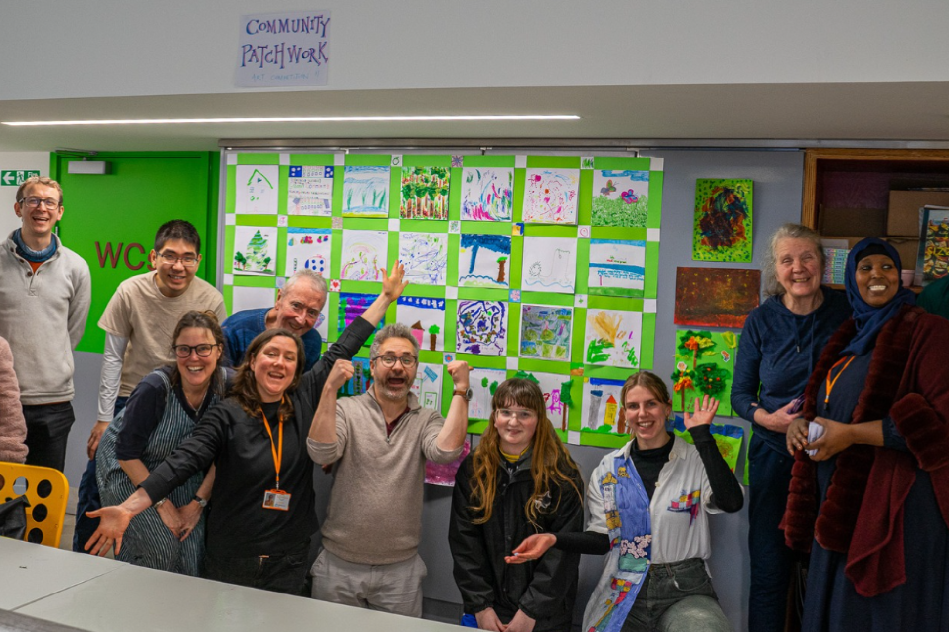 Members of North Kensington Community Energy celebrating after winning grant funding, gathered together and smiling
